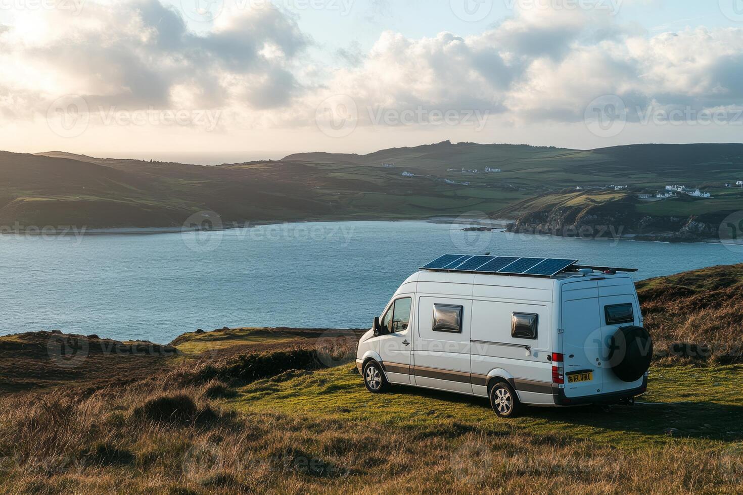 A beautifully designed campervan with a solar panel overlooks a picturesque lake, offering sustainable electricity for unforgettable adventures in this serene location, ideal for nature lovers photo