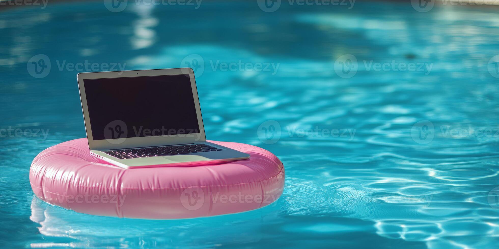 A modern laptop rests on a pink pool float, bobbing in clear water, symbolizing the blend of work and relaxation for the workaholic seeking balance in their busy life and enjoyment photo
