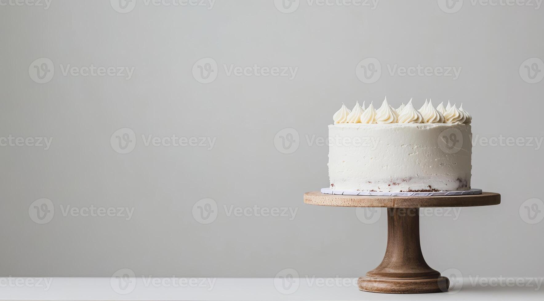 A stunning and beautifully minimalistic white birthday cake is elegantly displayed on a wooden cake stand, making it absolutely perfect for celebrations as well as delightful photo opportunities