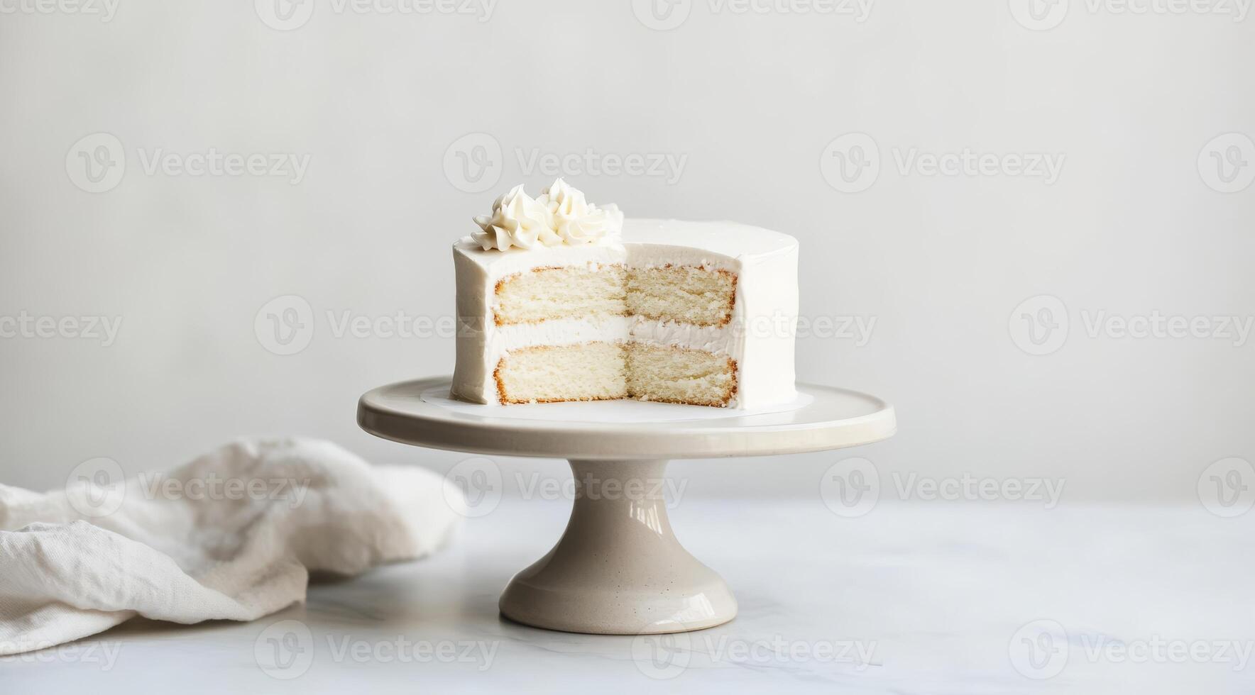 A minimalistic white birthday cake is elegantly displayed on a decorative stand, showcasing its rich frosting layers, making it the perfect centerpiece for any memorable celebration photo