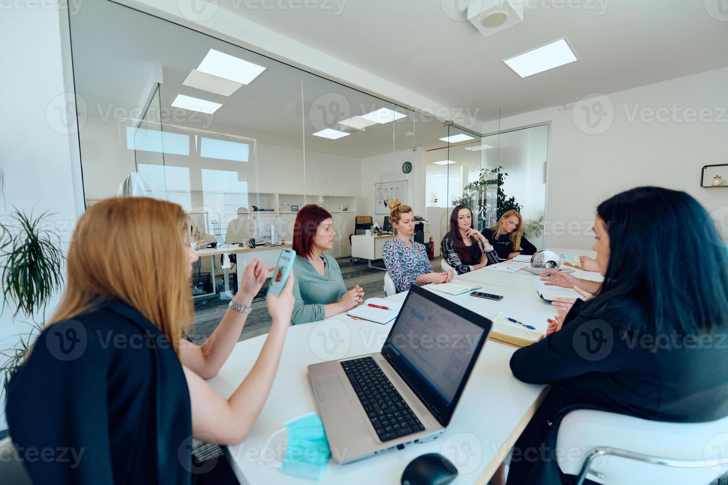 Diverse Business Team Discussing Projects in a Modern Glass Office. photo