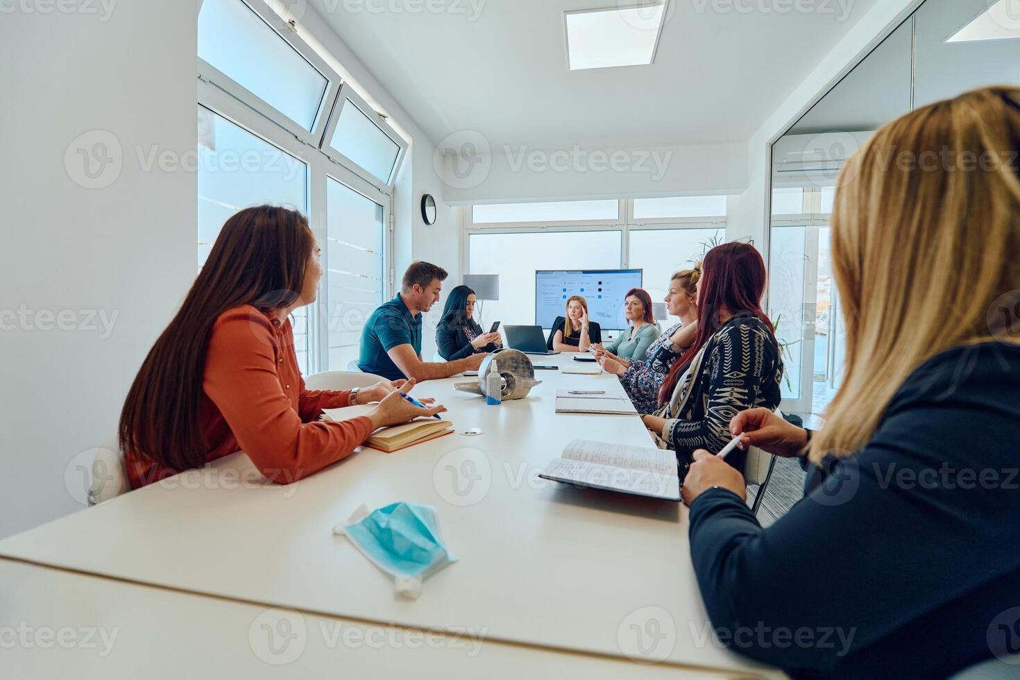 Diverse Business Team Discussing Projects in a Modern Glass Office. photo