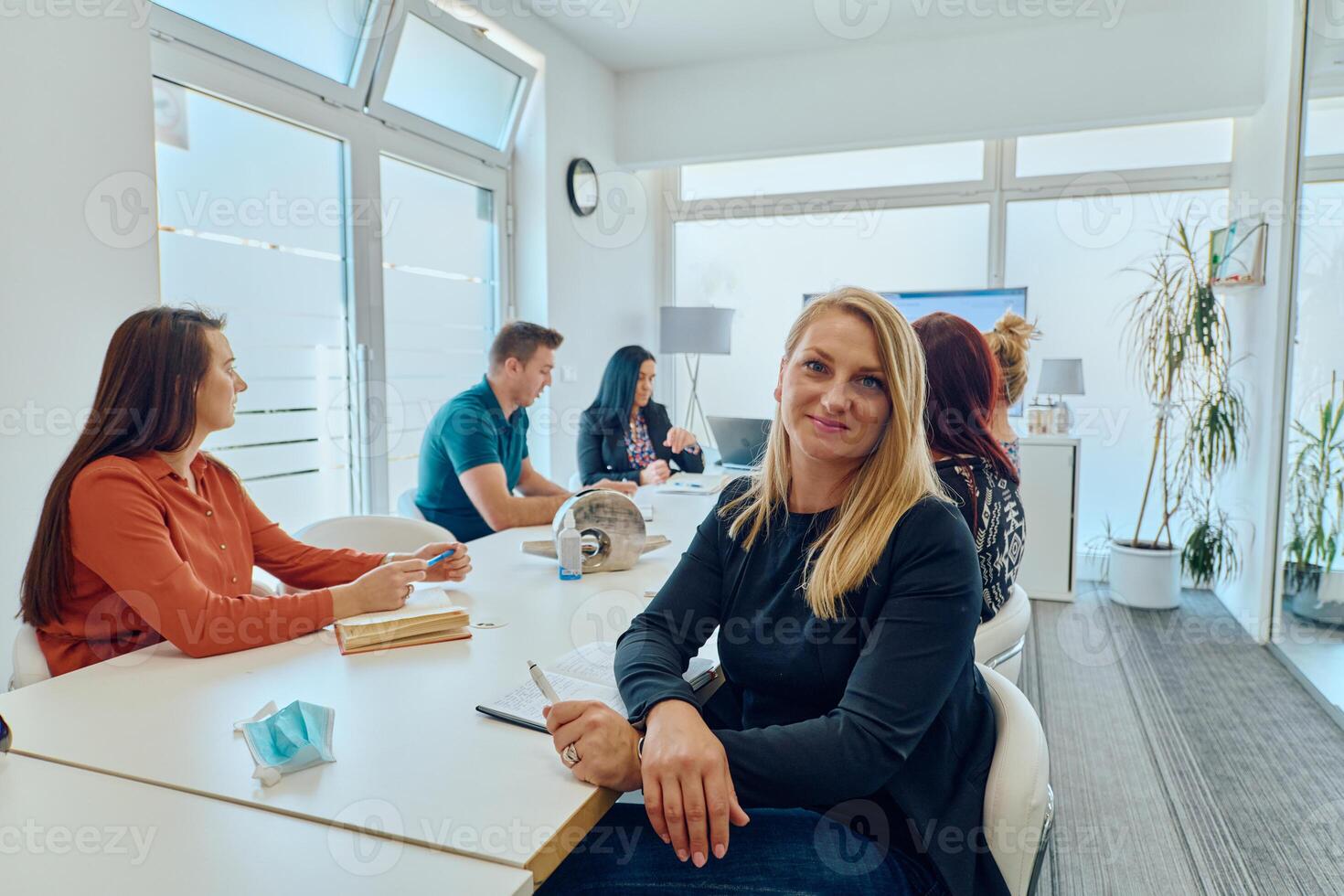 Diverse Business Team Discussing Projects in a Modern Glass Office. photo