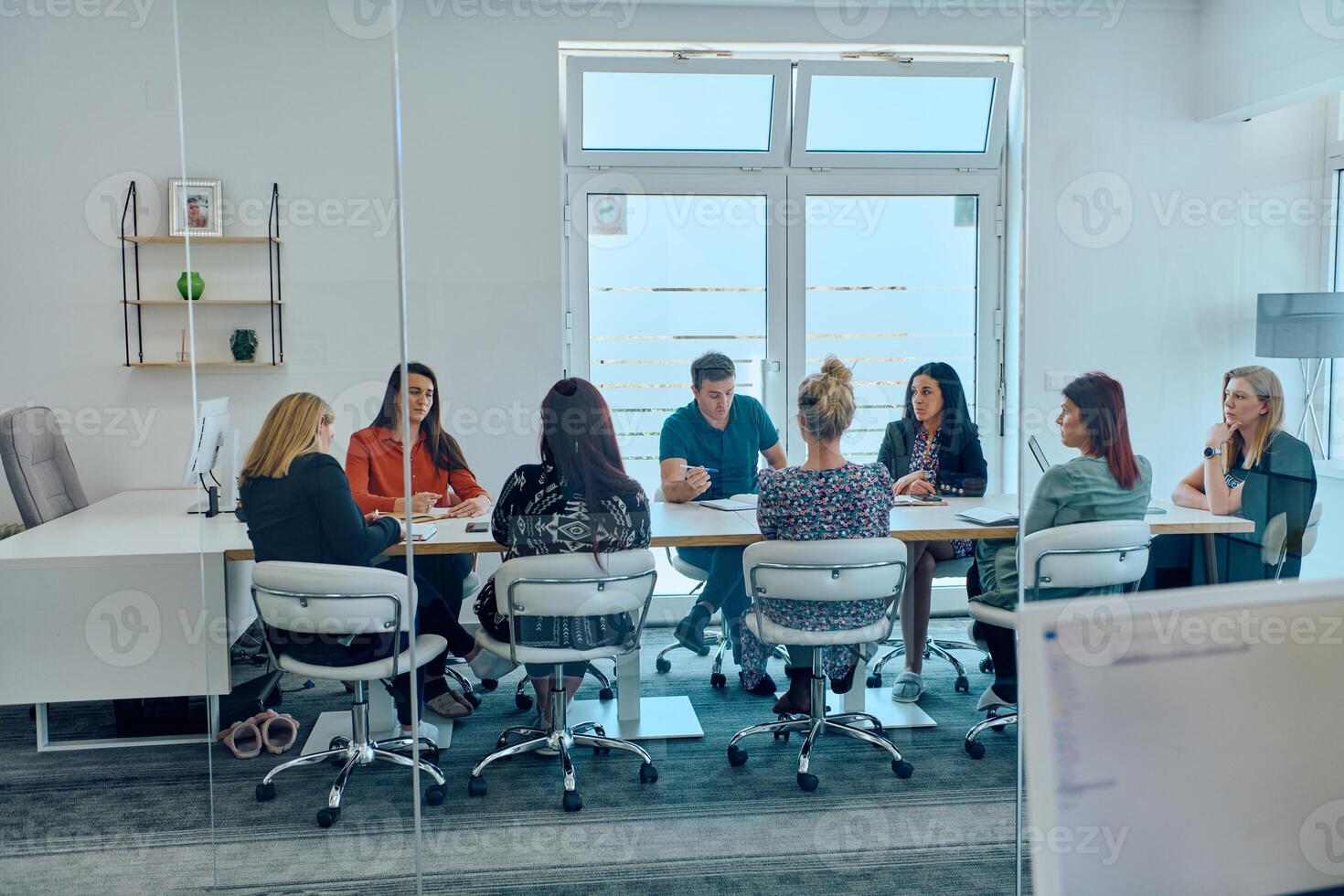 Diverse Business Team Discussing Projects in a Modern Glass Office. photo