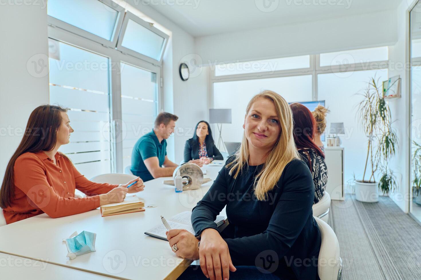 Diverse Business Team Discussing Projects in a Modern Glass Office. photo