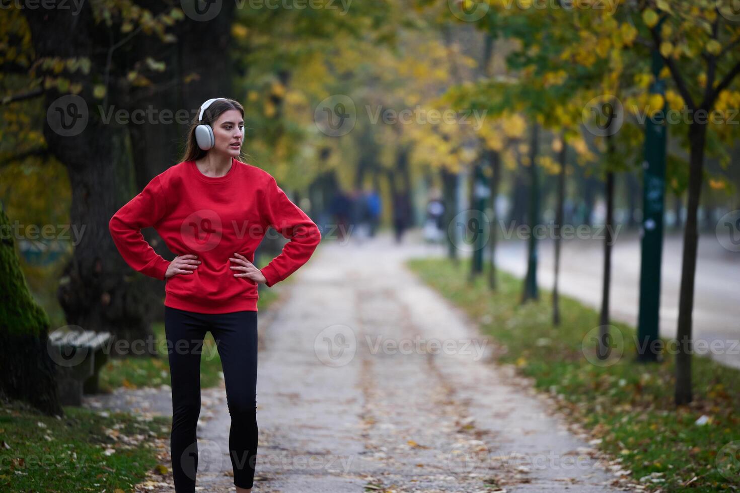 Athletic young woman taking a breath and relaxing after jogging and stretching. Woman Training and Workout Exercises On Street. photo