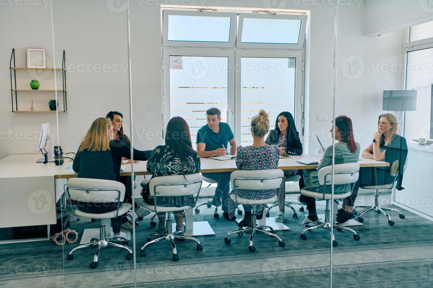Diverse Business Team Discussing Projects in a Modern Glass Office. photo