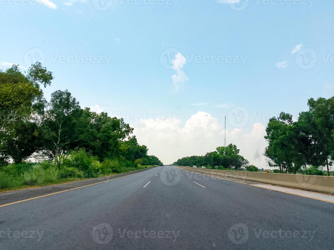 Highway road side view with green trees and blue sky photo