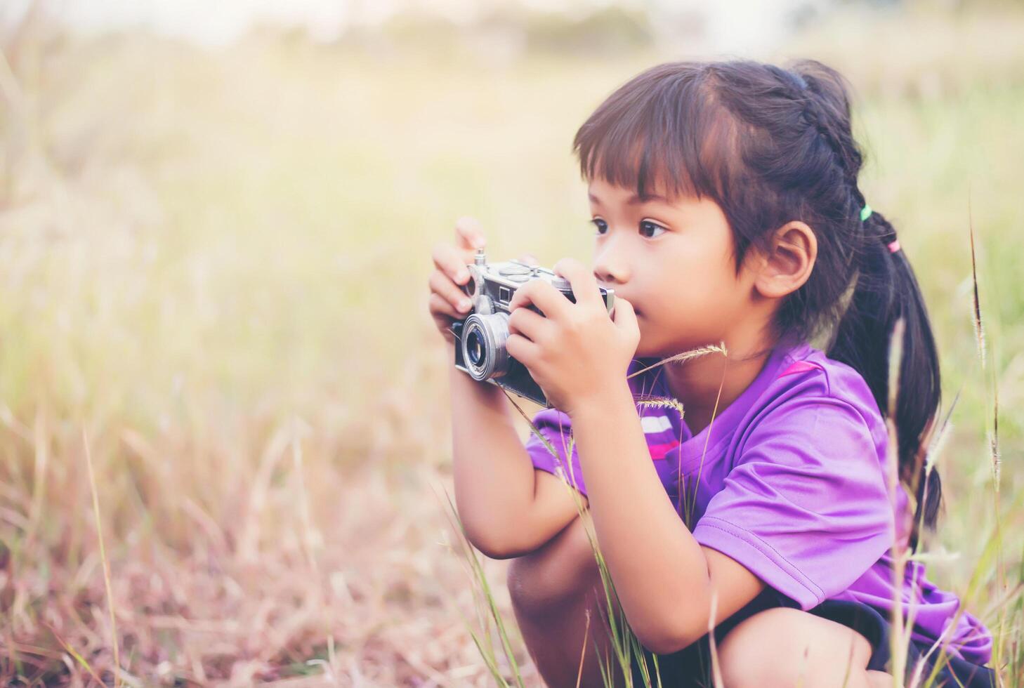 Woman with camera hiding behind the tree photo