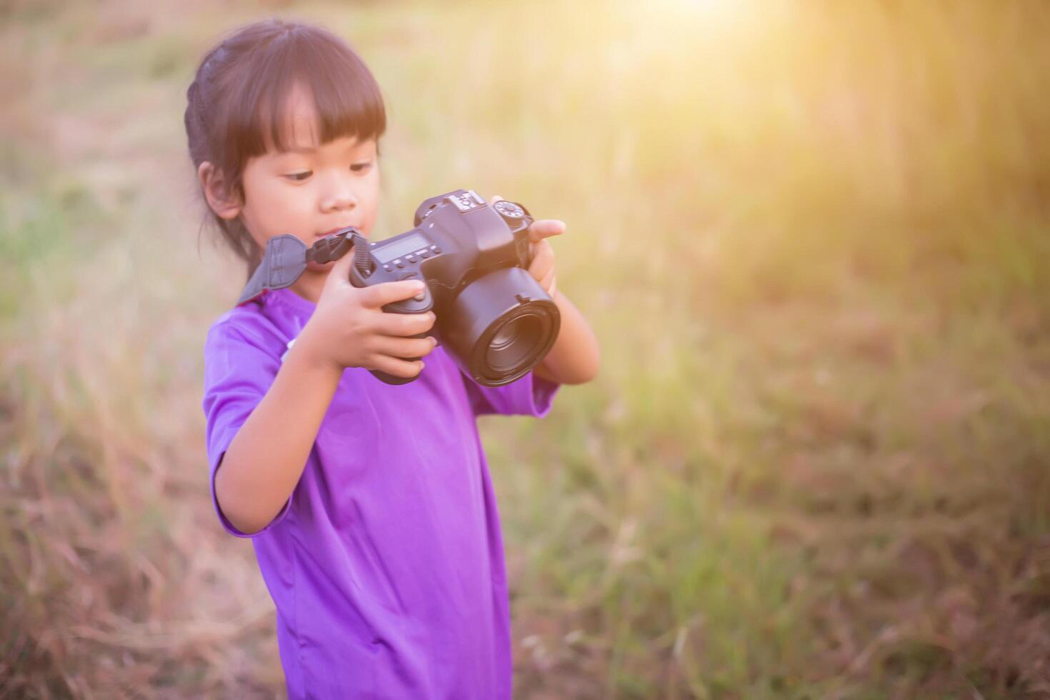 Woman with camera hiding behind the tree photo