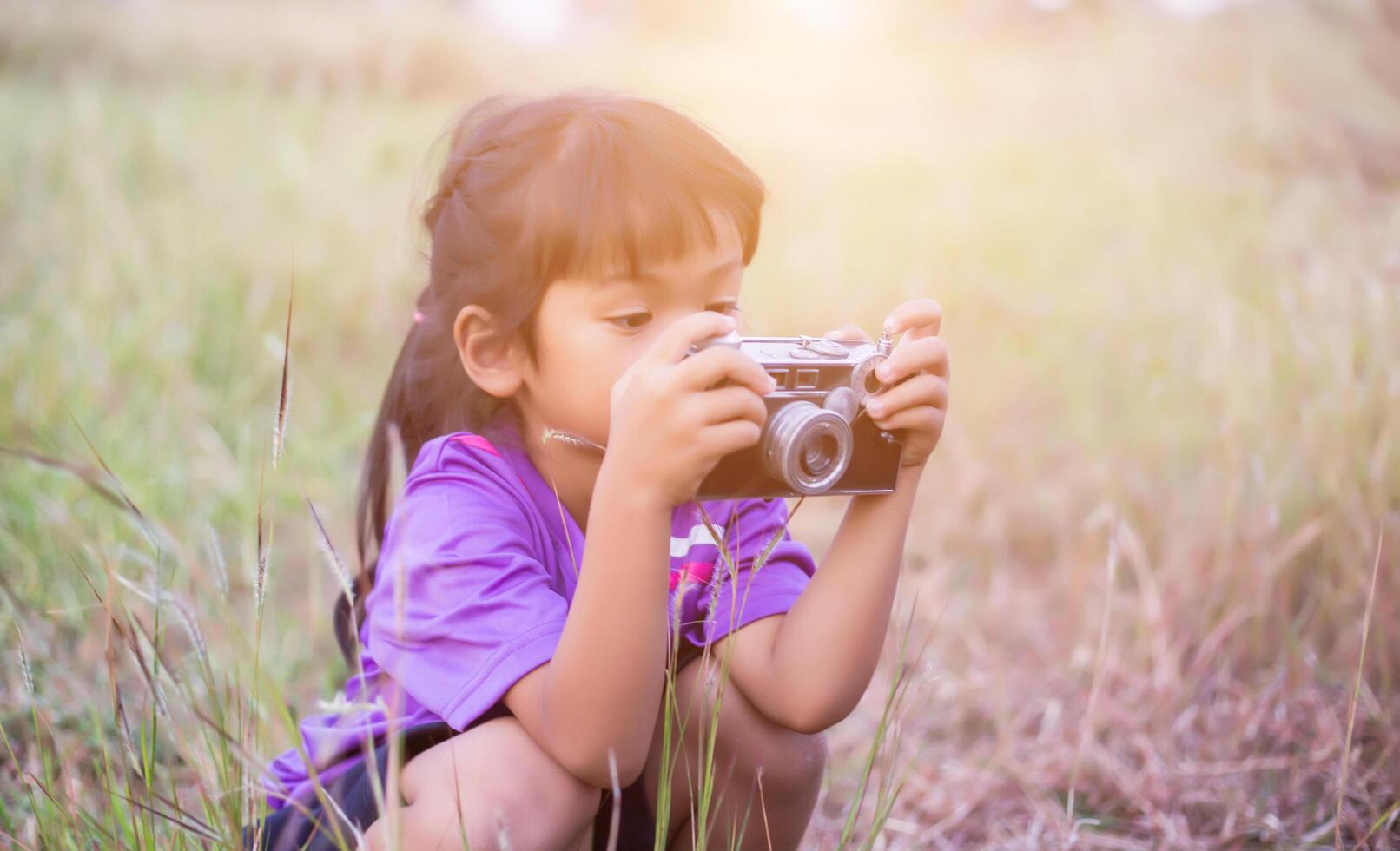 Woman with camera hiding behind the tree photo
