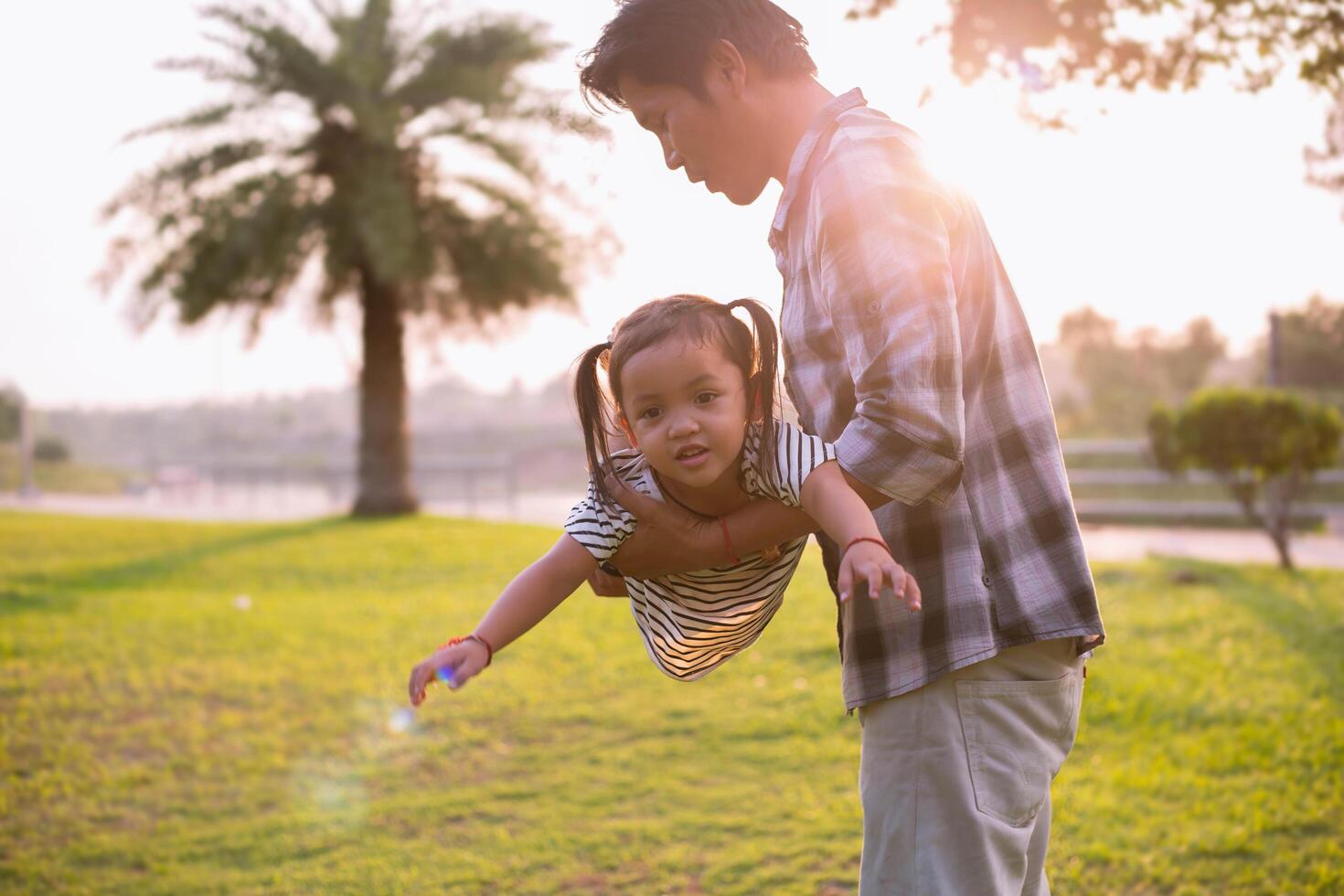 A silhouette of a happy young father harmonious family outdoors. laughing and playing in the summer on the sunset background.SSTKHome photo