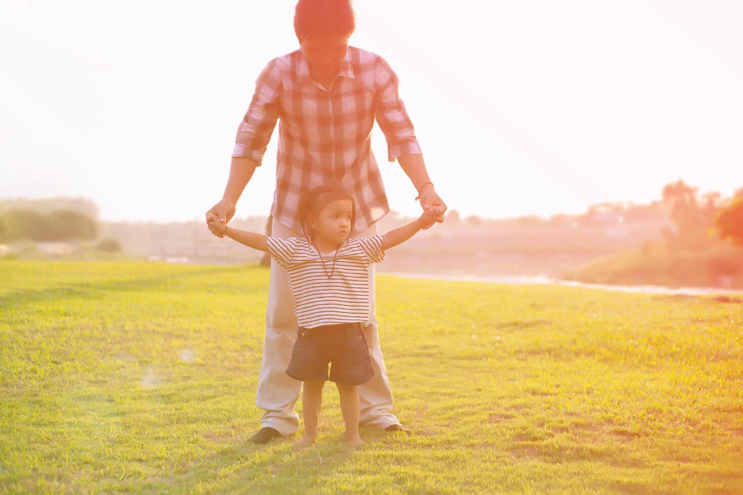 A silhouette of a happy young father harmonious family outdoors. laughing and playing in the summer on the sunset background.SSTKHome photo