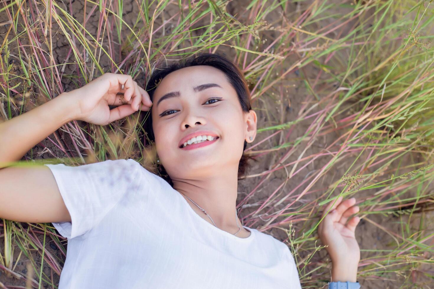 Young hipster woman lying in flower field after she tired for reading soft and blurred background photo