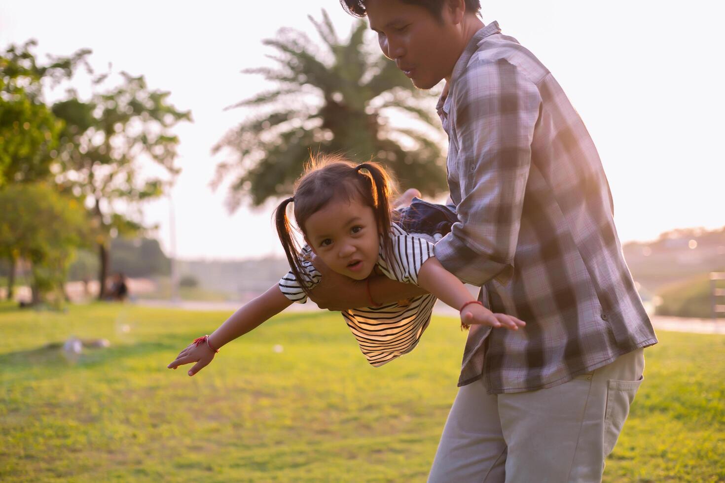 A silhouette of a happy young father harmonious family outdoors. laughing and playing in the summer on the sunset background.SSTKHome photo