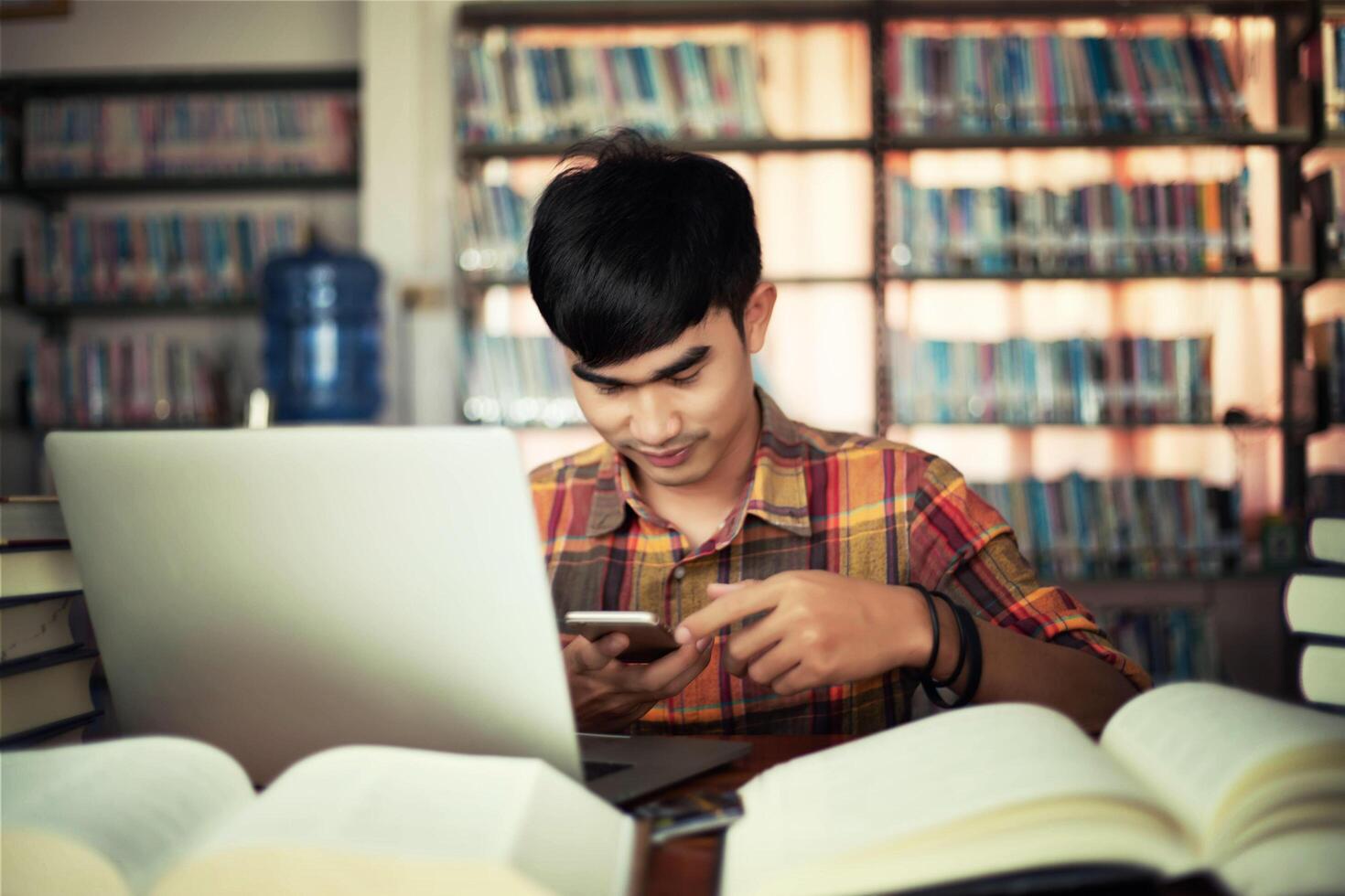 Young male student studying in the library photo