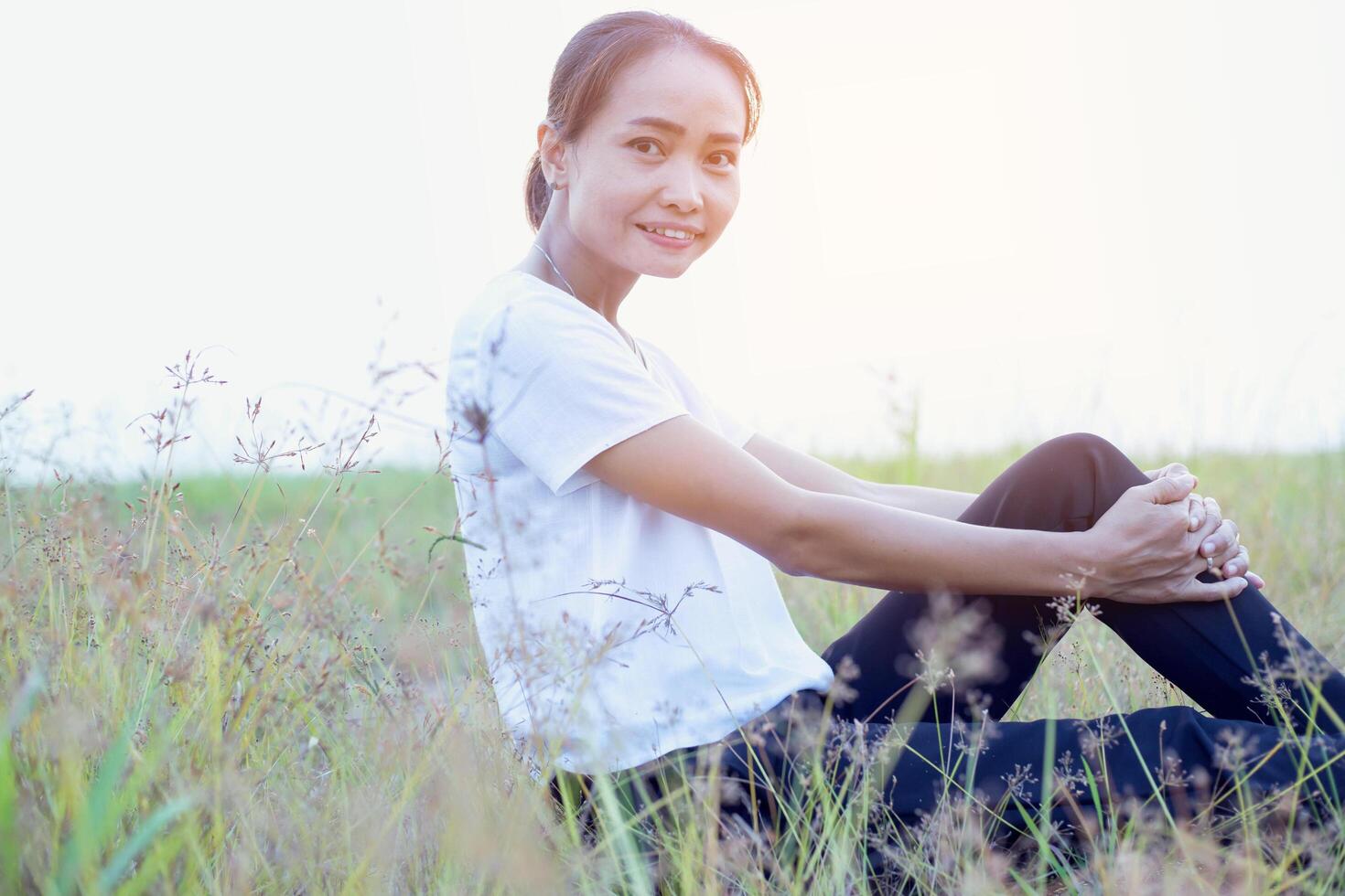 Young hipster woman lying in flower field after she tired for reading soft and blurred background photo