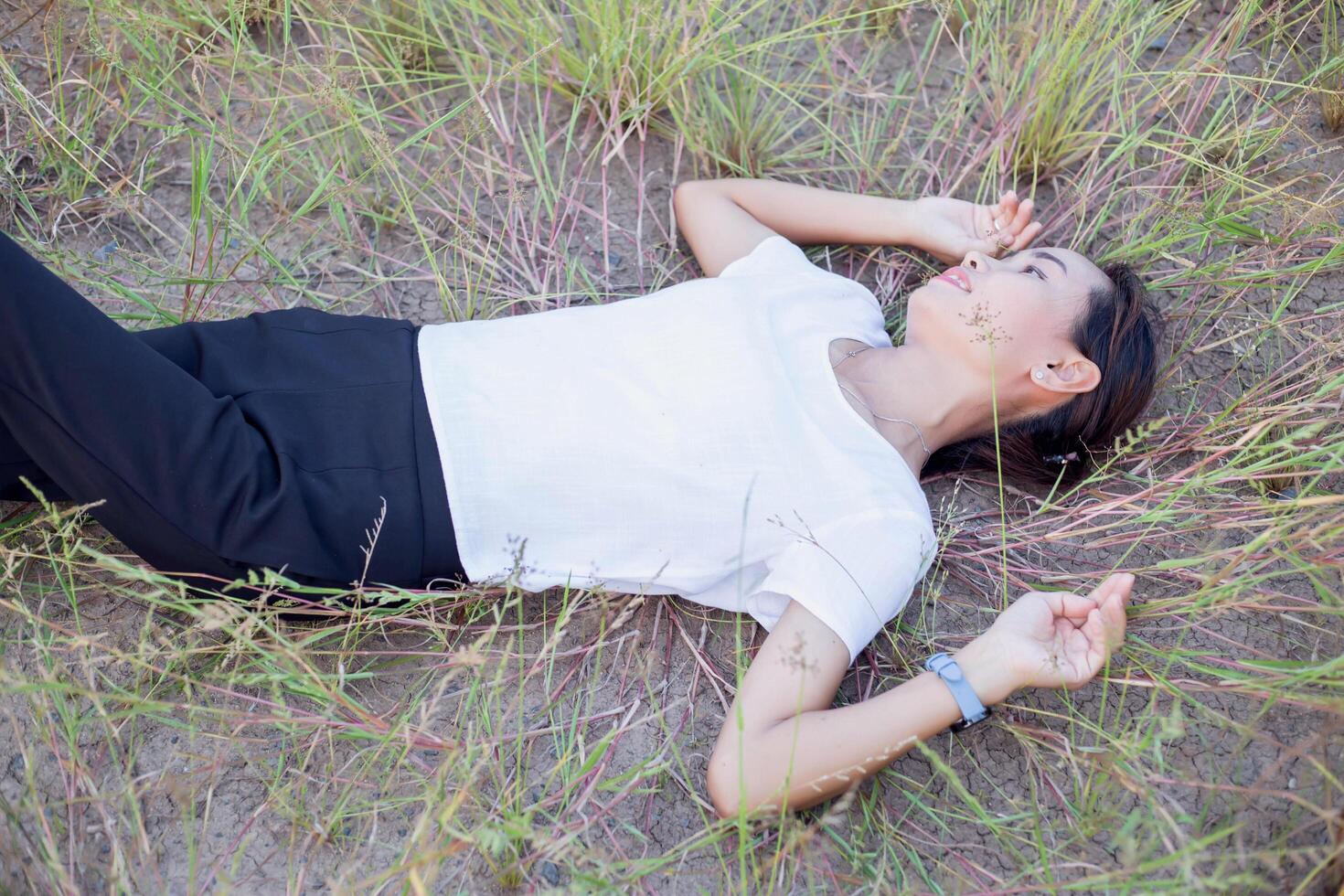 Young hipster woman lying in flower field after she tired for reading soft and blurred background photo
