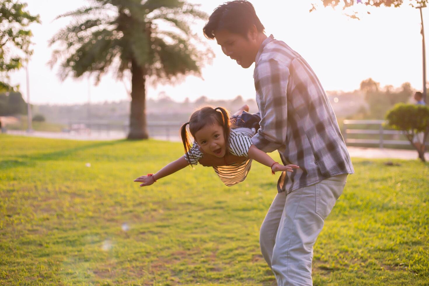 A silhouette of a happy young father harmonious family outdoors. laughing and playing in the summer on the sunset background.SSTKHome photo