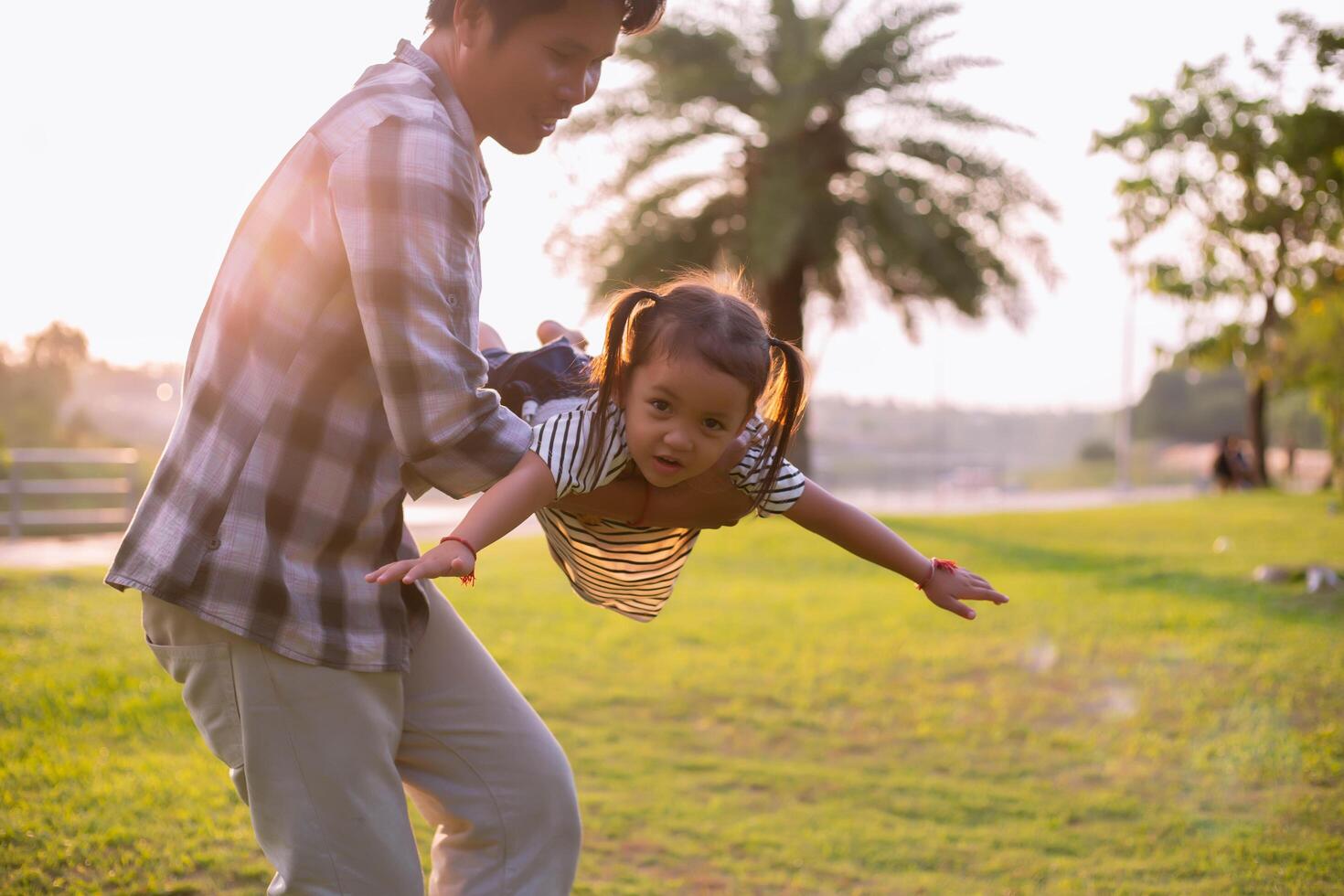 A silhouette of a happy young father harmonious family outdoors. laughing and playing in the summer on the sunset background.SSTKHome photo