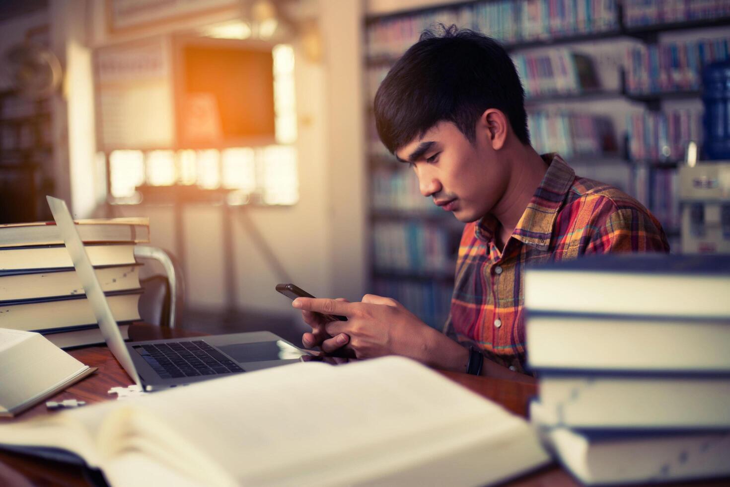 Young male student studying in the library photo