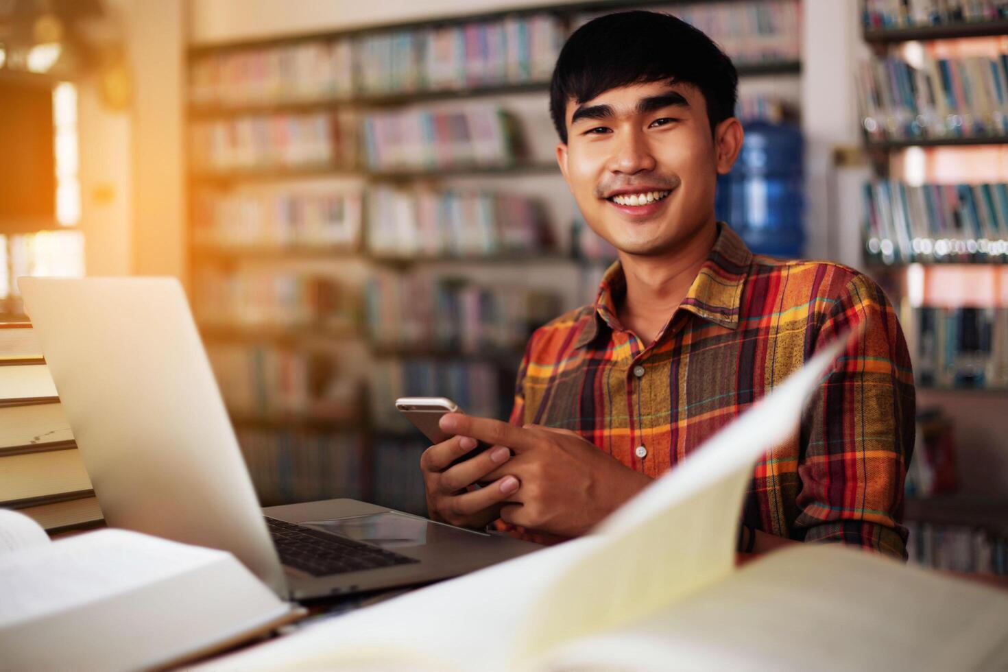 Young male student studying in the library photo
