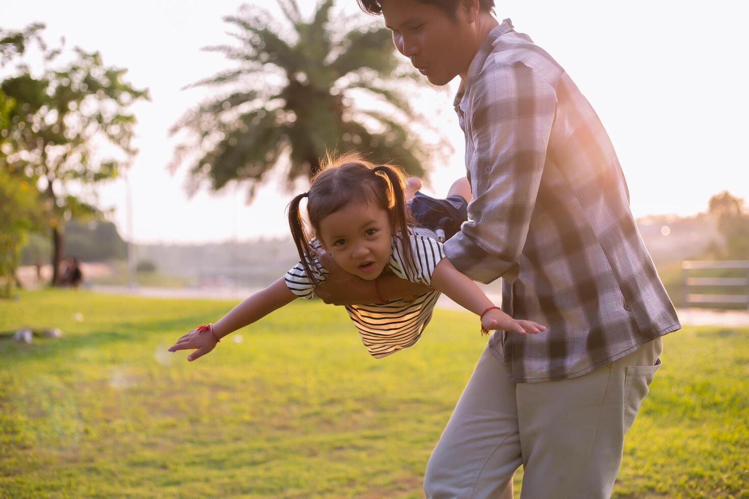 A silhouette of a happy young father harmonious family outdoors. laughing and playing in the summer on the sunset background.SSTKHome photo