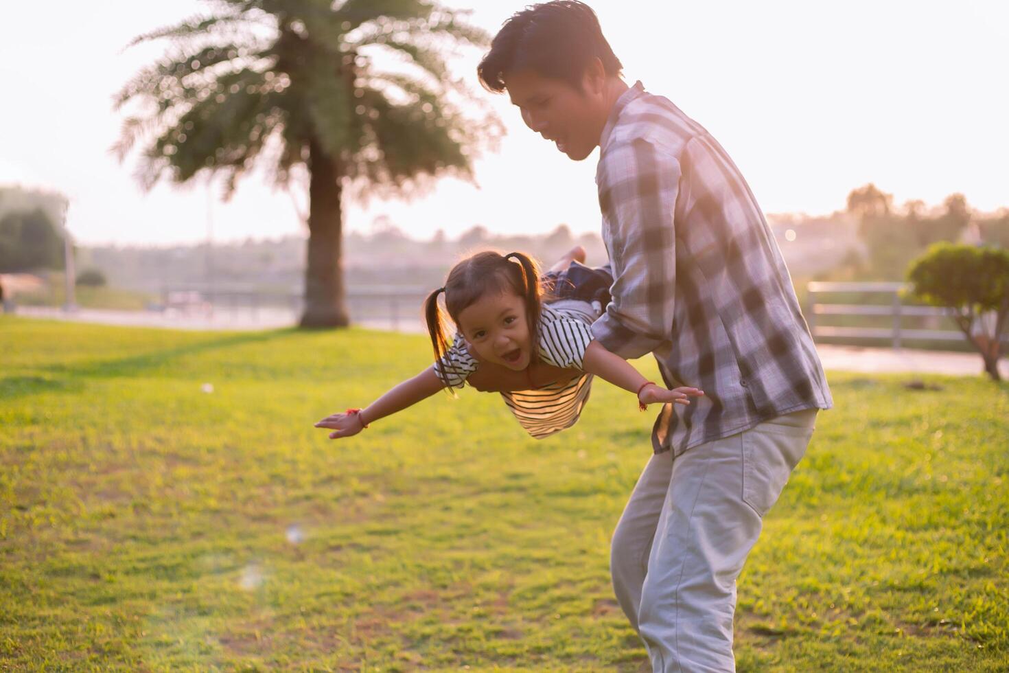 A silhouette of a happy young father harmonious family outdoors. laughing and playing in the summer on the sunset background.SSTKHome photo