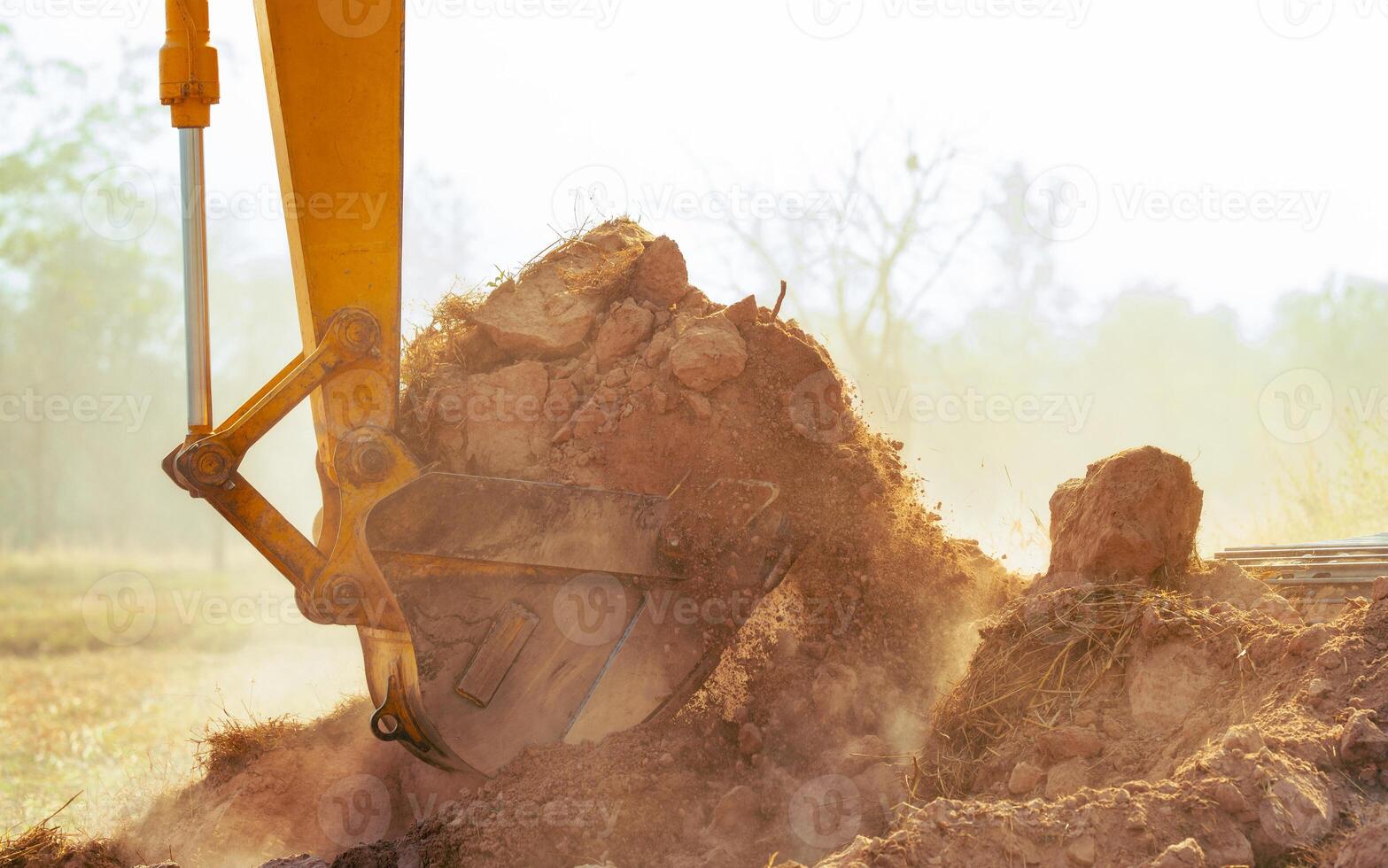 Closeup bucket of backhoe digging the soil at construction site. Crawler excavator digging on demolition site. Excavating machine. Earth moving equipment. Excavation vehicle. Construction business. photo