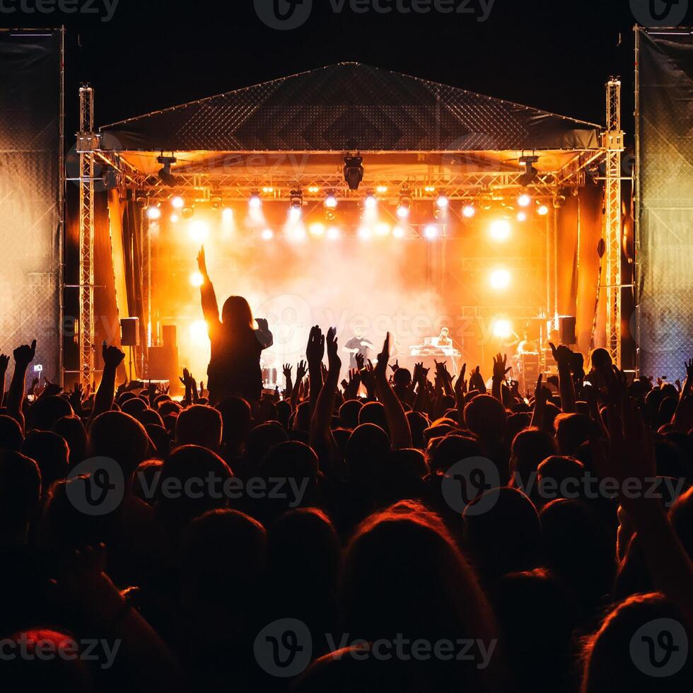 silhouettes of a heads and hands of a crowd of fans at a live concert photo