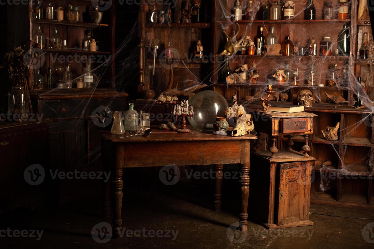 Halloween background Shelves with alchemy tools Skull spiderweb bottle with poison candles photo