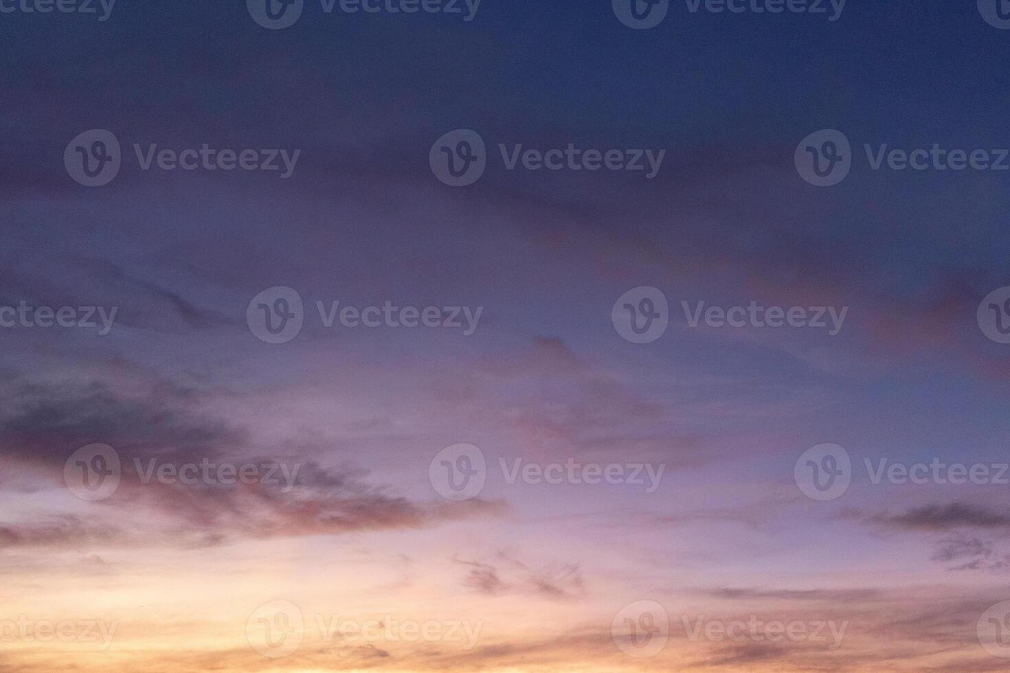 A serene evening sky with soft hues of purple, pink, and orange, fading into twilight photo