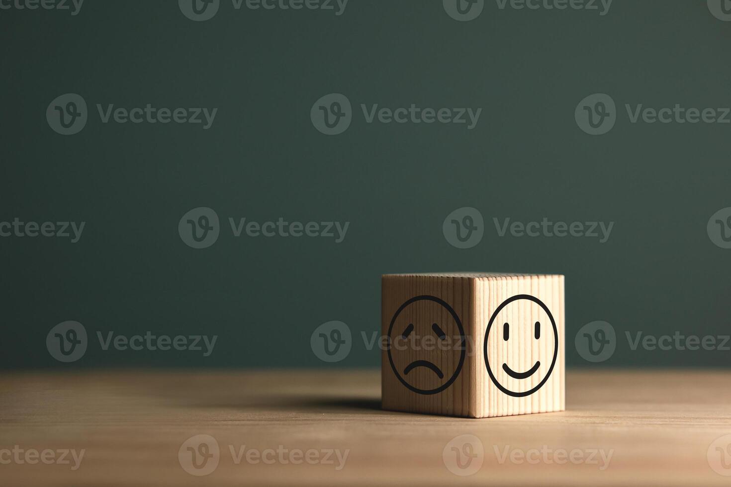 A smiling face on bright side and sad face on dark side of wooden block. Concept business for satisfaction assessment and mental health concepts for positive thinking and emotional states. photo