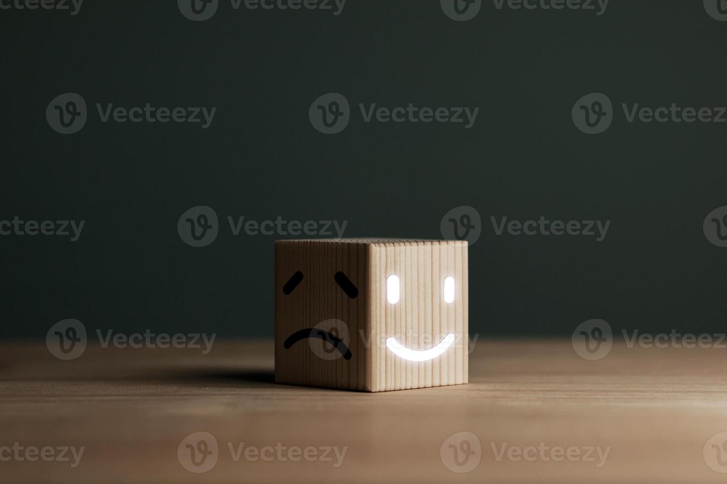 A smiling face on bright side and sad face on dark side of wooden block. Concept business for satisfaction assessment and mental health concepts for positive thinking and emotional states. photo