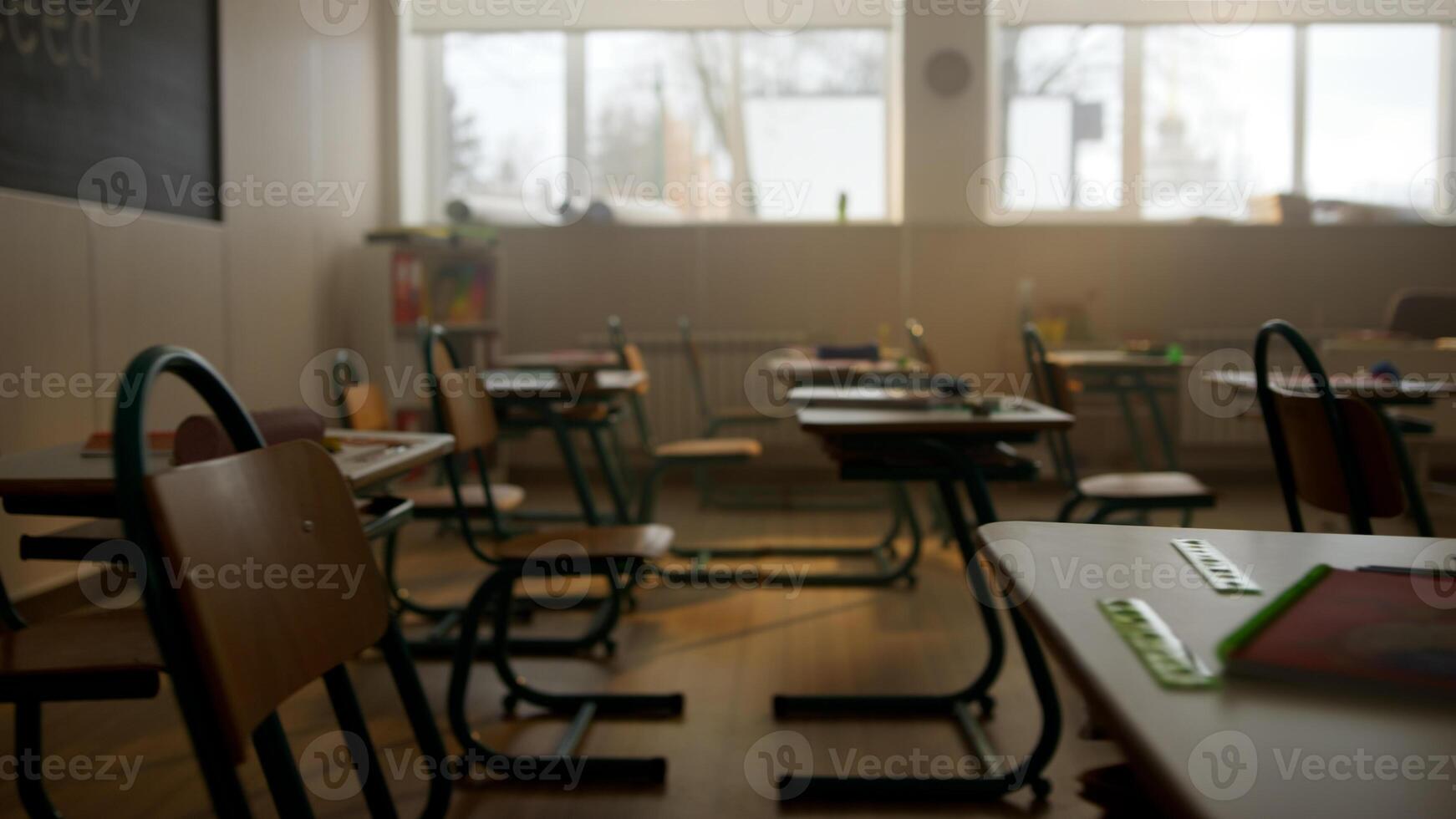 Empty classroom with desks, chairs and chalkboard. photo
