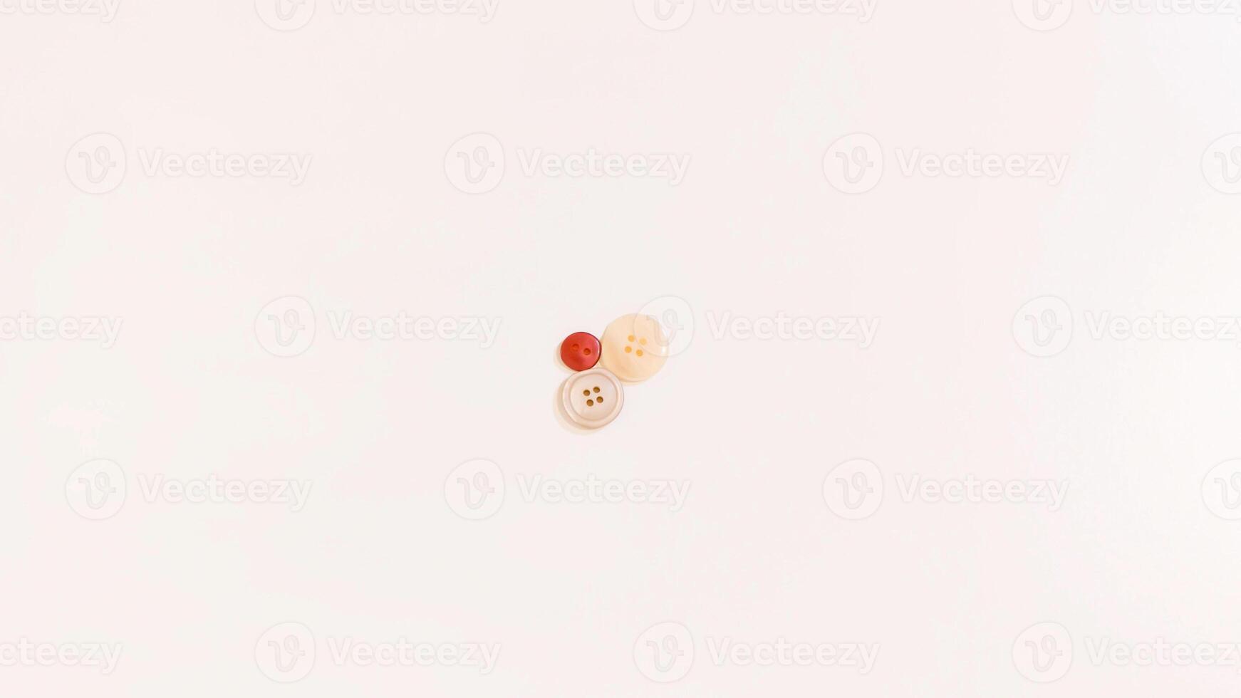 Buttons of various colors and shapes scattered on a white background. photo