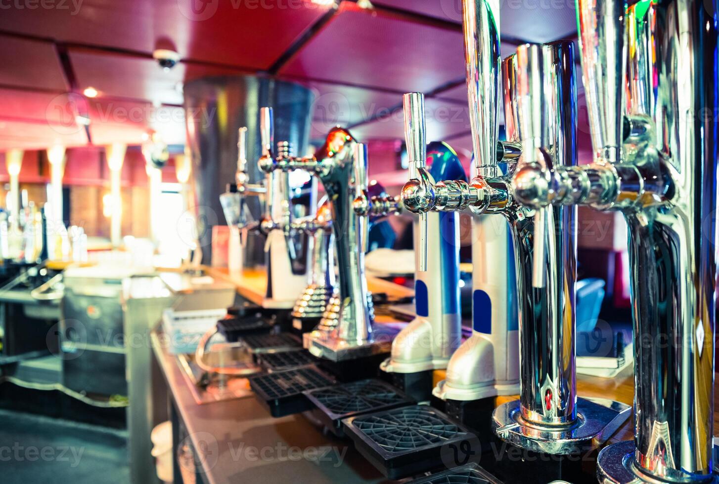 man bartender hand at beer tap pouring beer in glass in bar or pub photo