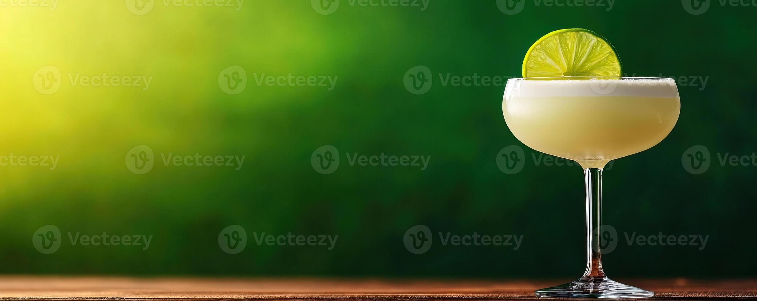 A refreshing cocktail garnished with a lime slice, served in an elegant glass against a vibrant green background. photo