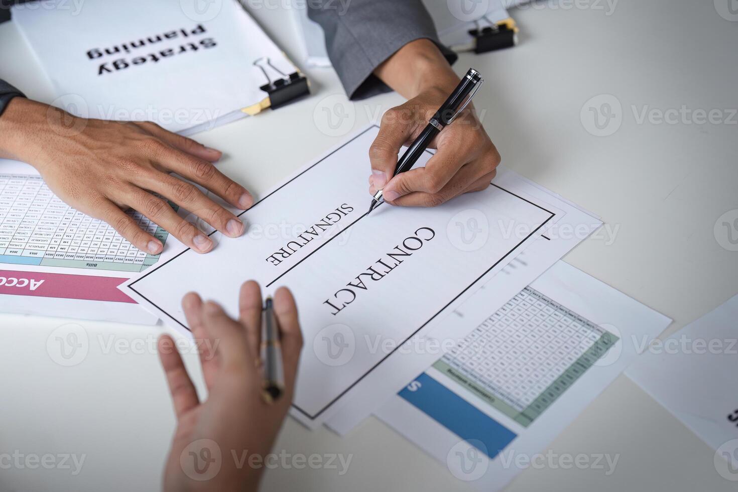 Businessman Signing Contract Agreement in Modern Office Setting with Documents and Strategy Planning photo
