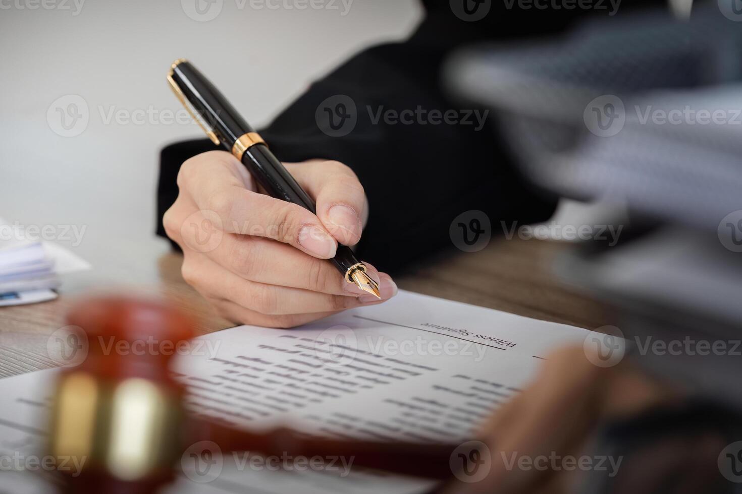 Young Female Lawyer Introducing Business Contract Law with Pen in Hand and Legal Documents on Desk photo