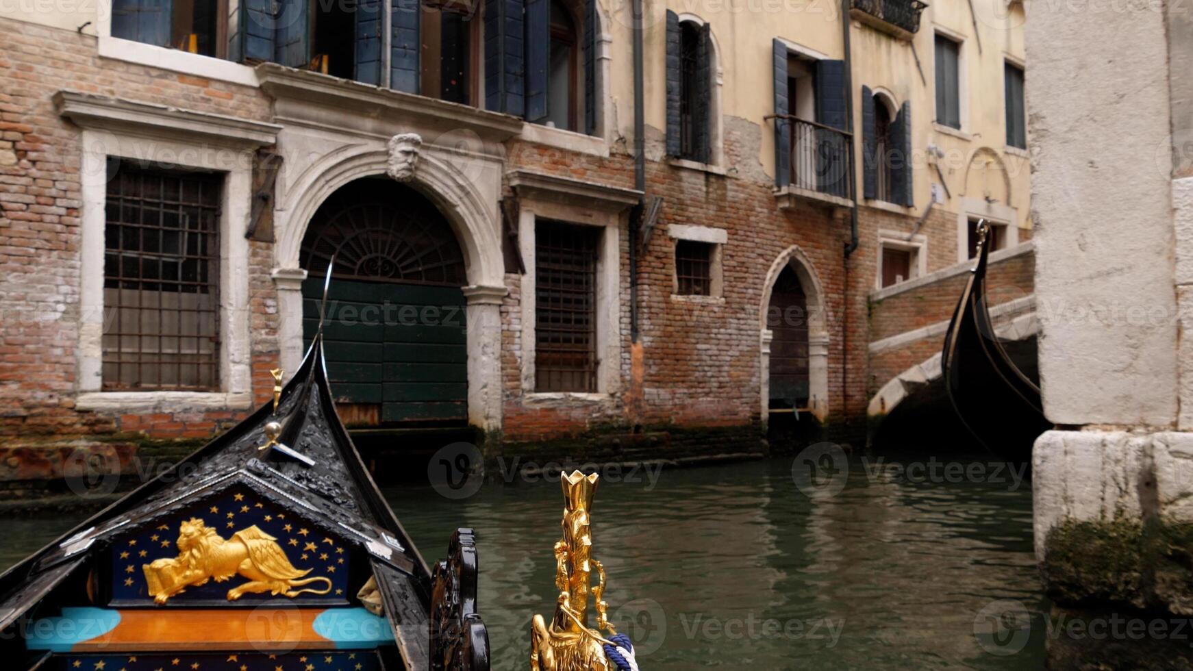 View of the Grand Canal from a gondola in Venice, Italy. The front part of the gondola on the background of the views of Venice photo