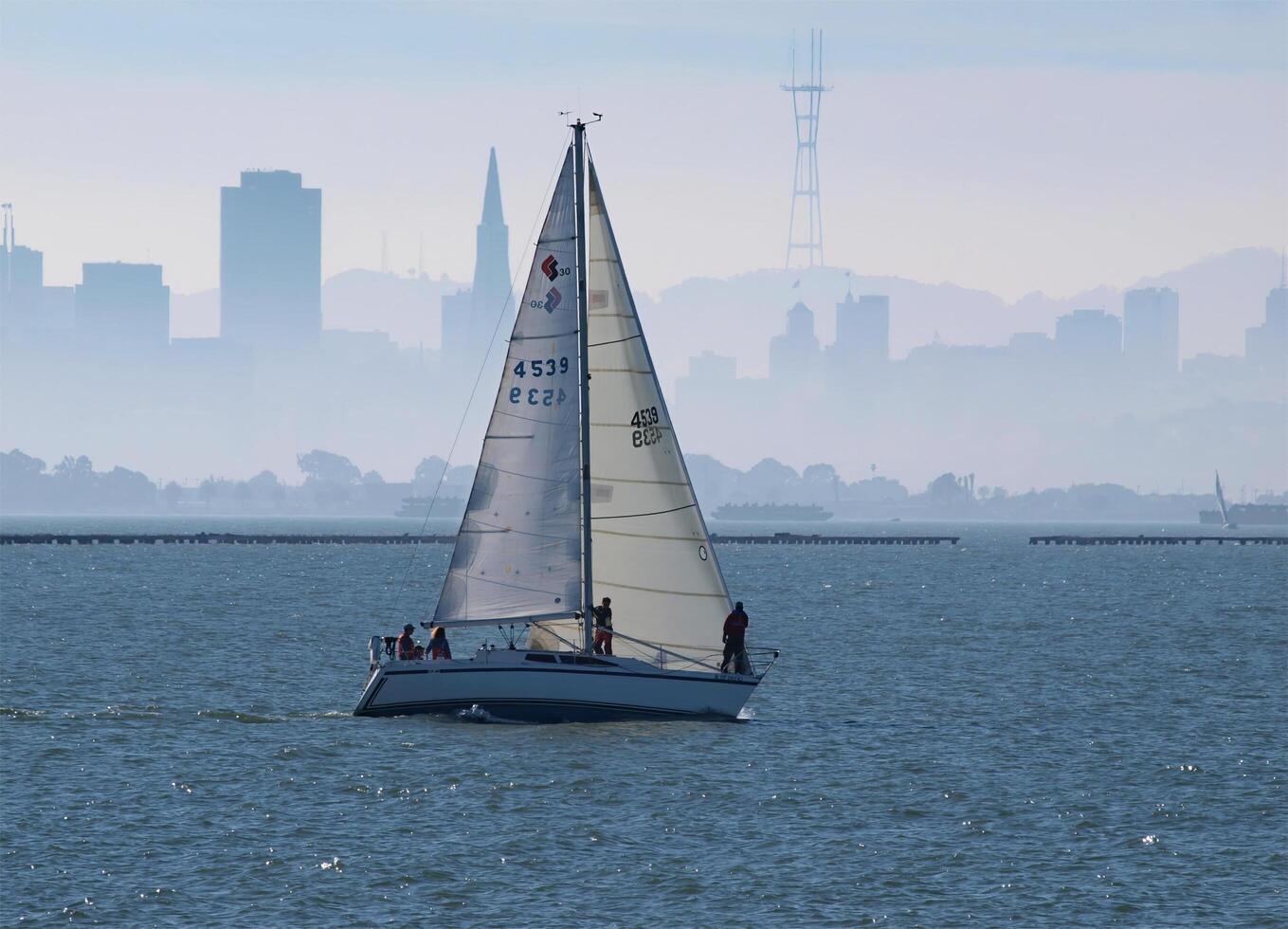 Berkeley, CA, 2010 - Sailboat Underway In San Francisco Bay With Haze Covered City photo
