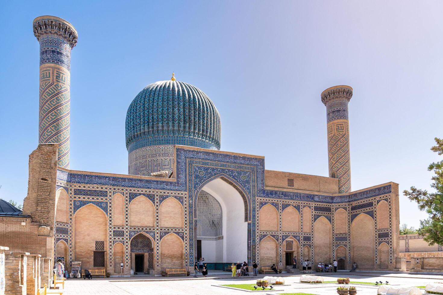 Tashkent, Uzbekistan-august 12, 2023-people in front of the Tamerlane Mausoleum with decorated tombs, mosaics and carvings during a sunny day photo