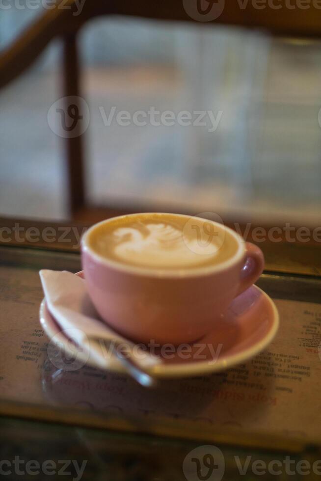 A cup of coffee latte with froth art on the table photo