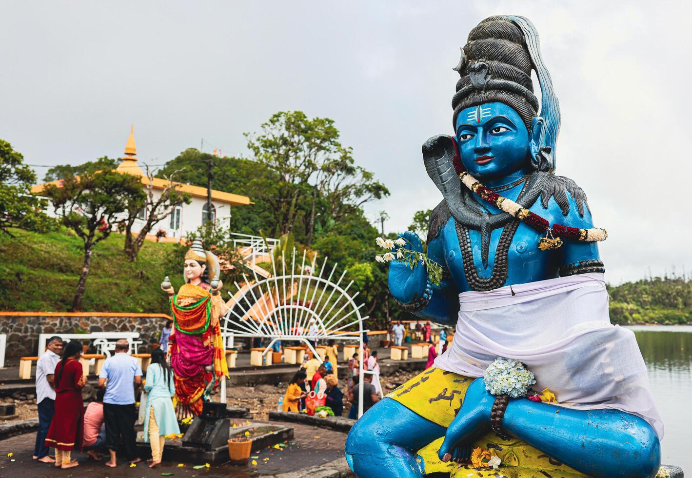 A statue of a man, representing a Hindu deity, holding a snake in his hand. photo