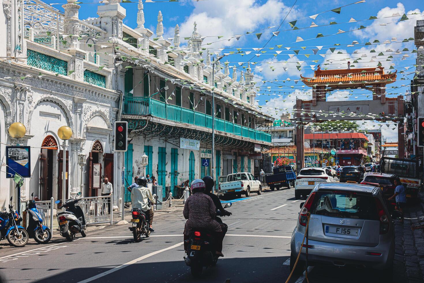 Port Louis, Mauritius - January 14, 2023 - A diverse group of individuals standing in front of a building, located in Port Louis City, Mauritius, with a prominent mosque in the background. photo