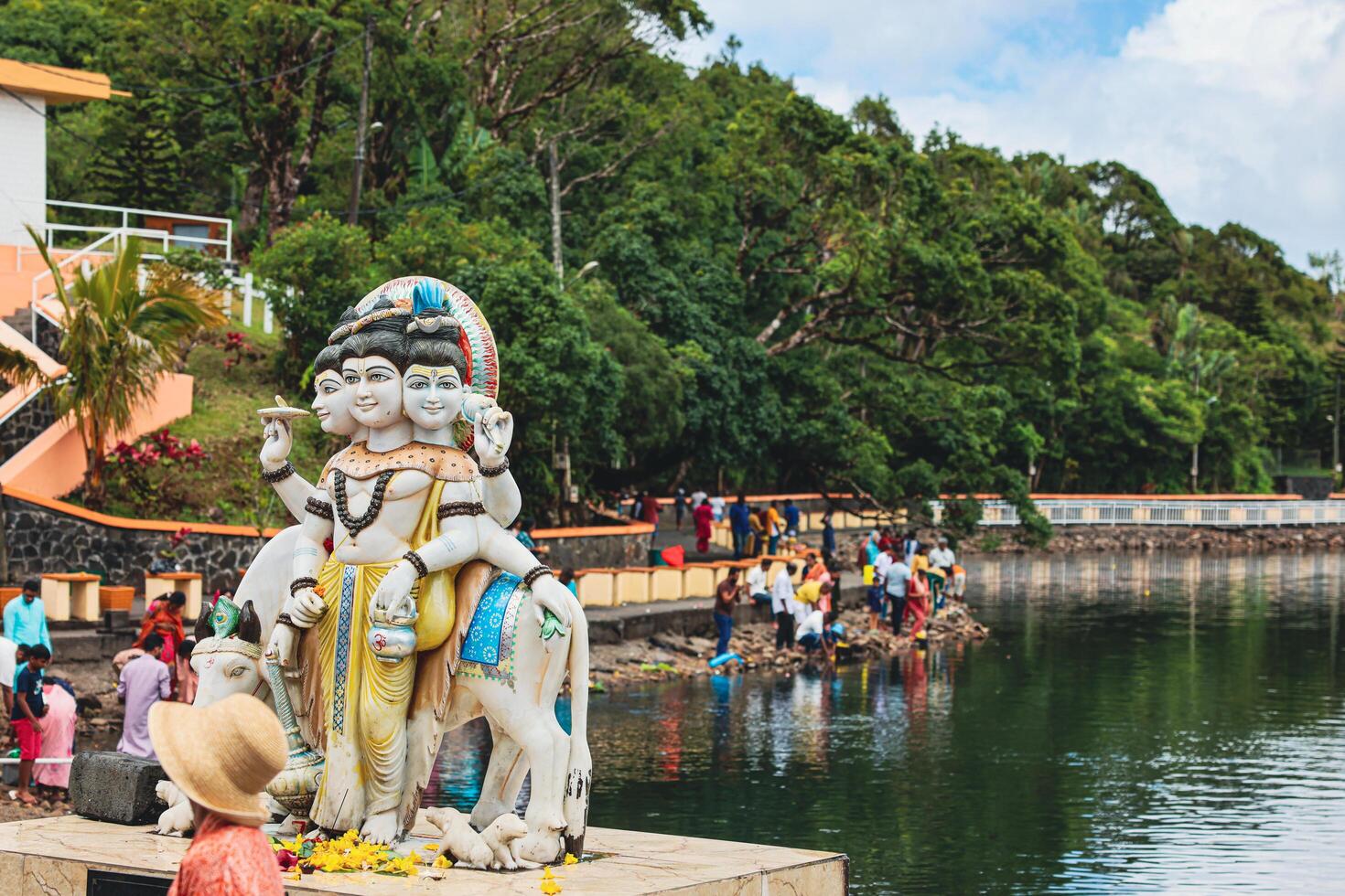 A statue of a man, representing a Hindu deity, holding a snake in his hand. photo