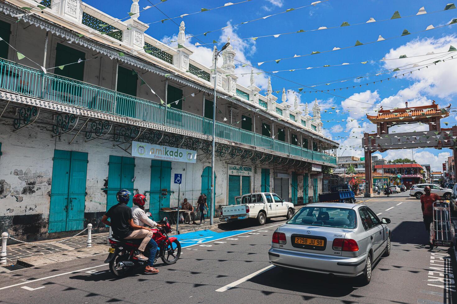 Port Louis, Mauritius - January 14, 2023 - A diverse group of individuals standing in front of a building, located in Port Louis City, Mauritius, with a prominent mosque in the background. photo