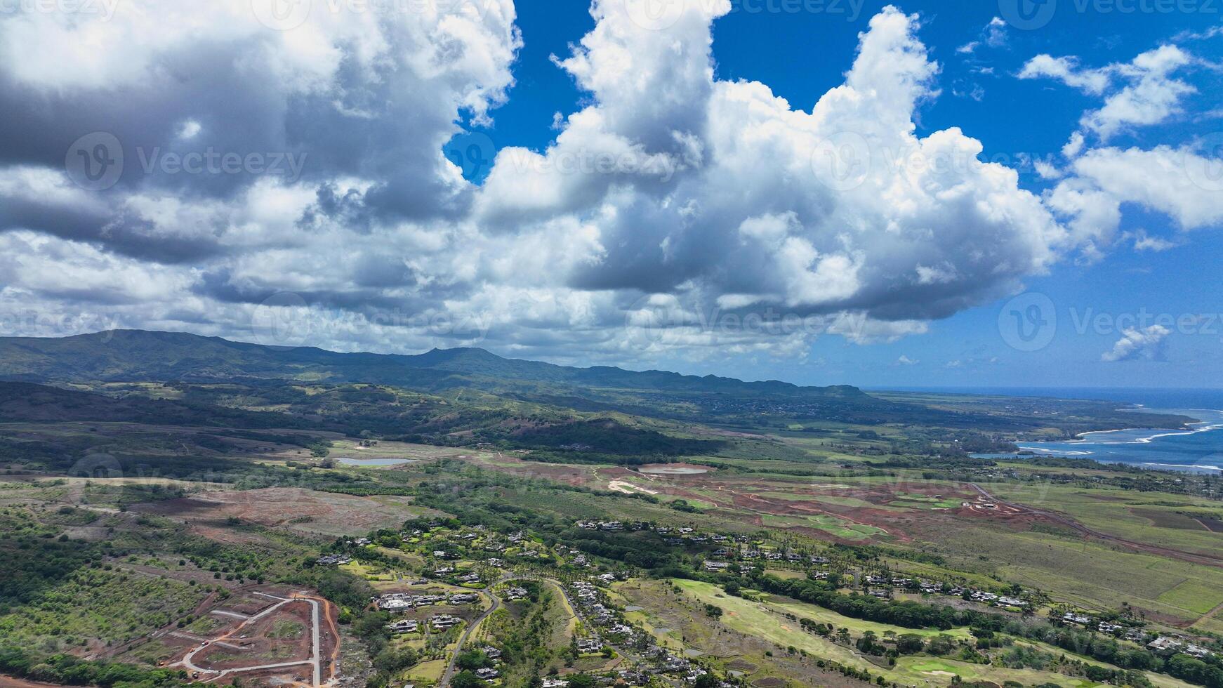 An aerial view showcasing the beautiful rural landscape of Mauritius with majestic mountains in the background. photo