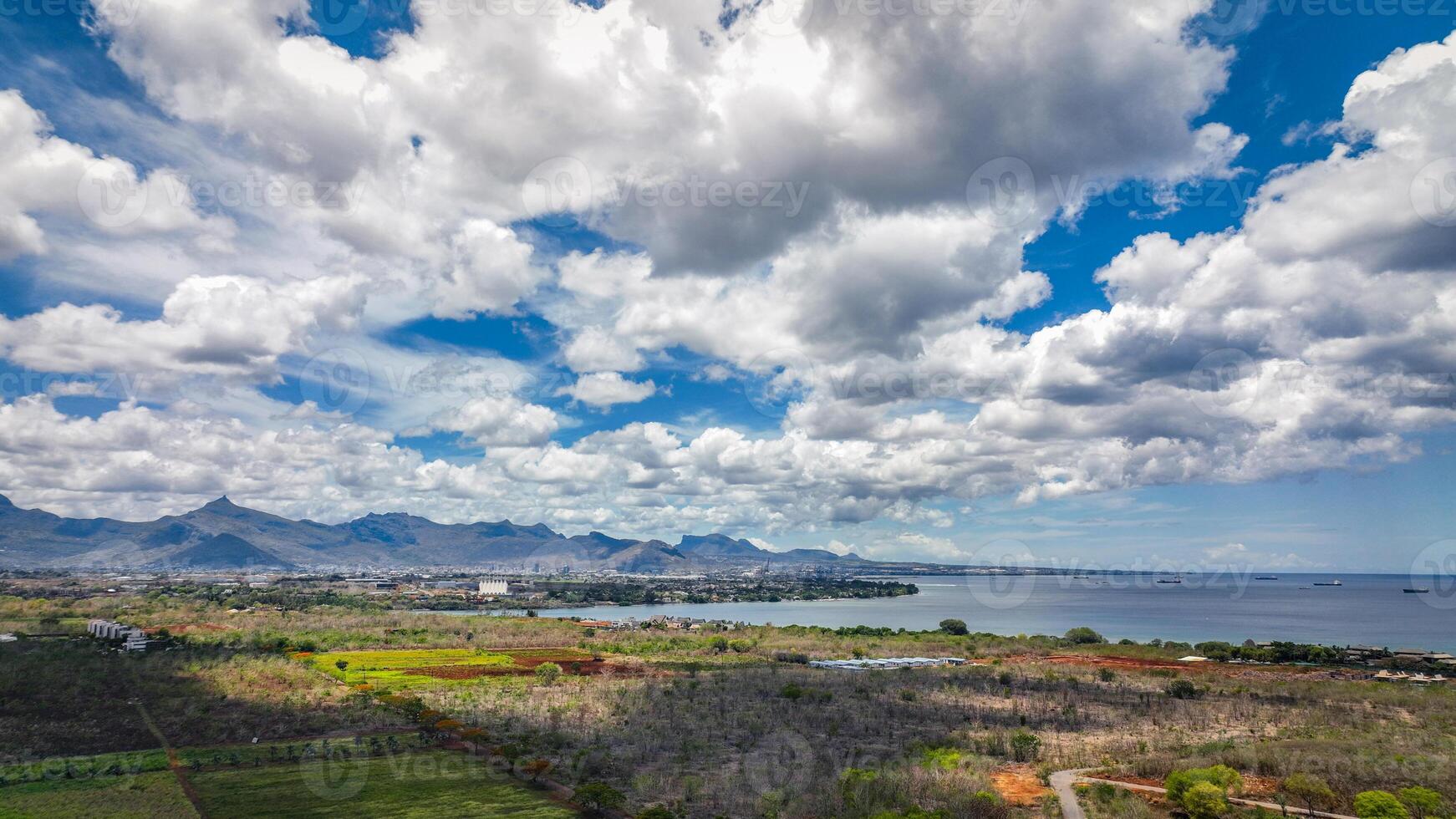 An aerial view showcasing the beautiful rural landscape of Mauritius with majestic mountains in the background. photo